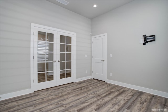 unfurnished room with hardwood / wood-style floors and french doors