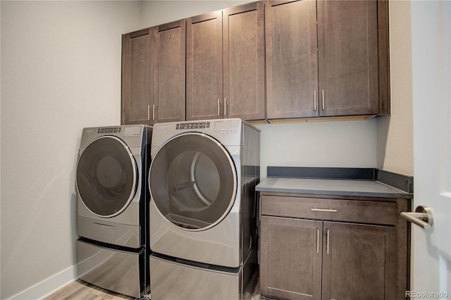 clothes washing area with light hardwood / wood-style floors, cabinets, and independent washer and dryer