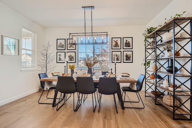 dining room with an inviting chandelier and light hardwood / wood-style flooring