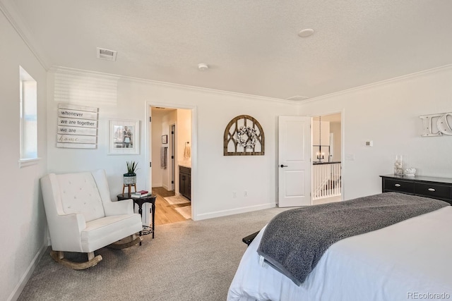 bedroom with ornamental molding, carpet, a textured ceiling, and ensuite bath