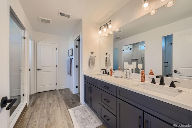 bathroom with a shower with door, vanity, and hardwood / wood-style flooring