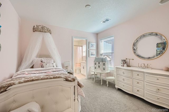 bedroom featuring light carpet, a textured ceiling, and ensuite bathroom