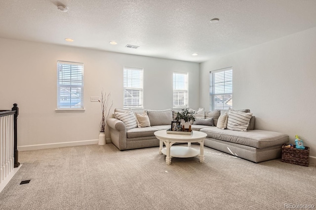 living room featuring light colored carpet and a textured ceiling