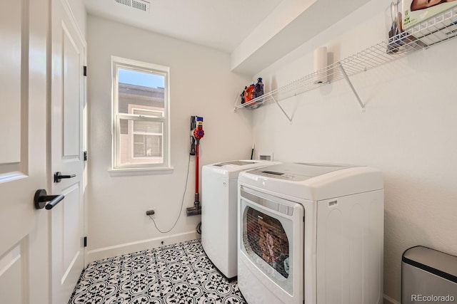 clothes washing area featuring separate washer and dryer and light tile patterned floors