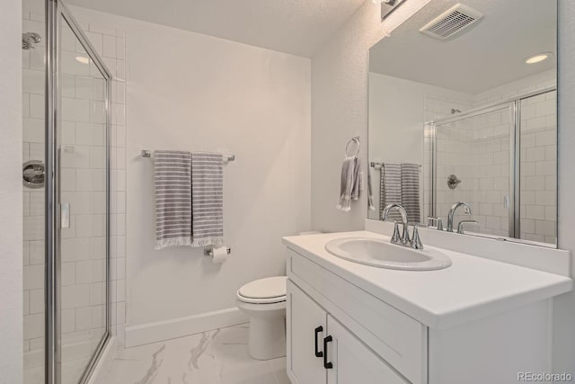 bathroom with vanity, a shower with shower door, and toilet