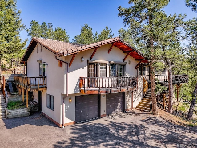 5336 High Rd, Evergreen, CO 80439 - mediterranean / spanish home featuring a garage, asphalt driveway, stairway, and stucco siding