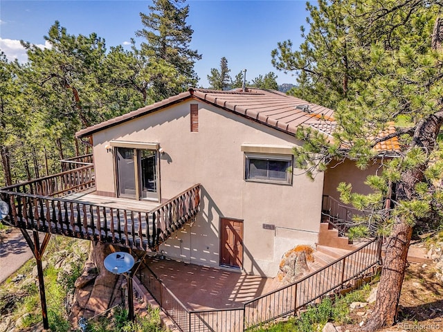 5336 High Rd, Evergreen, CO 80439 - rear view of property featuring stairway, stucco siding, a wooden deck, and a tiled roof