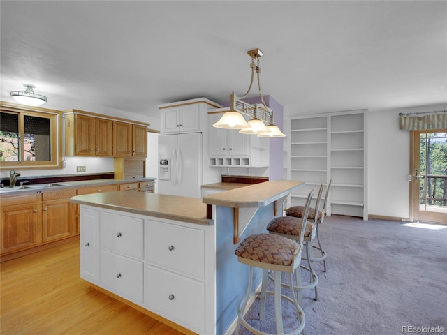 5336 High Rd, Evergreen, CO 80439 - kitchen with white fridge with ice dispenser, a kitchen bar, decorative light fixtures, open shelves, and light countertops
