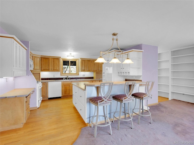 5336 High Rd, Evergreen, CO 80439 - kitchen featuring white appliances, open shelves, light countertops, a breakfast bar, and a kitchen island