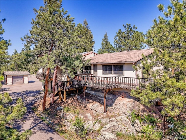 5336 High Rd, Evergreen, CO 80439 - view of front of property featuring a wooden deck, a tiled roof, an outdoor structure, a garage, and stucco siding