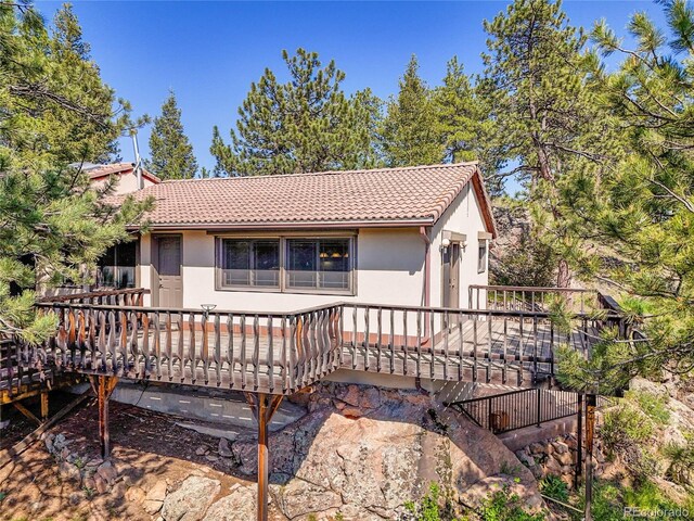 5336 High Rd, Evergreen, CO 80439 - rear view of house featuring a tiled roof, a wooden deck, and stucco siding