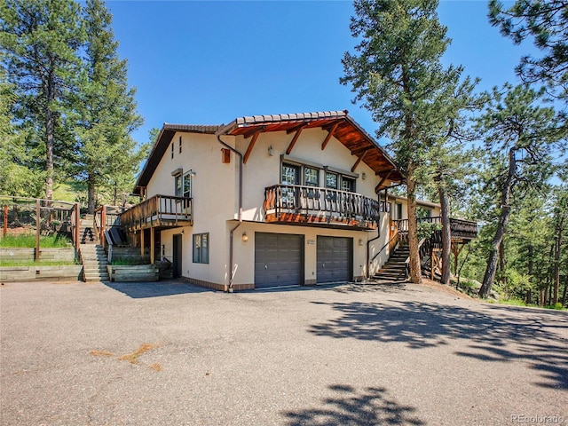 5336 High Rd, Evergreen, CO 80439 - view of front of property featuring stairway, driveway, stucco siding, a deck, and an attached garage
