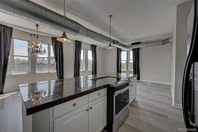 kitchen with tile countertops, a center island, stainless steel electric range, white cabinetry, and pendant lighting