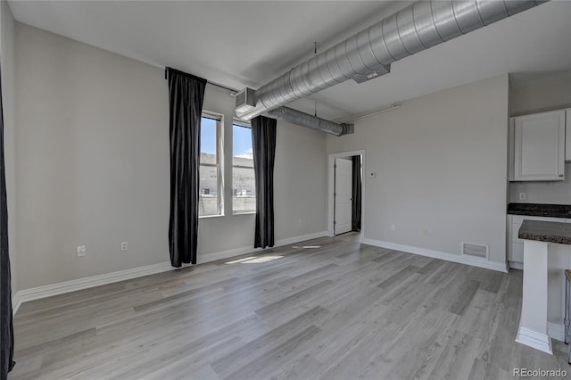 unfurnished room with baseboards, visible vents, and light wood-style floors