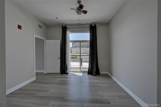 empty room with ceiling fan and light hardwood / wood-style floors