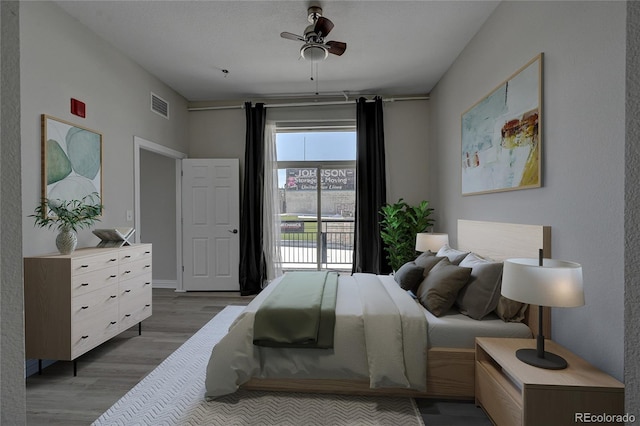 bedroom featuring wood finished floors, visible vents, and a ceiling fan