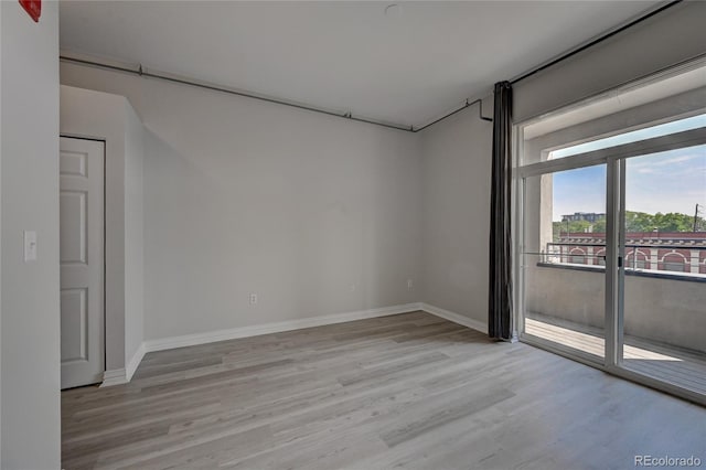 empty room with baseboards and light wood finished floors