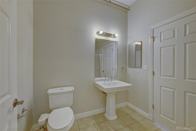 bathroom with baseboards, toilet, and tile patterned floors