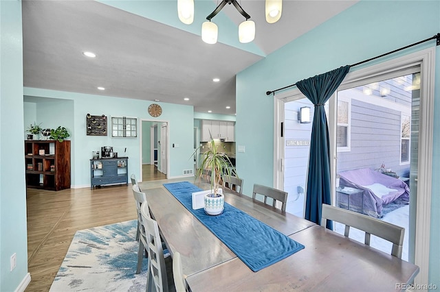 dining space with wood-type flooring and a chandelier