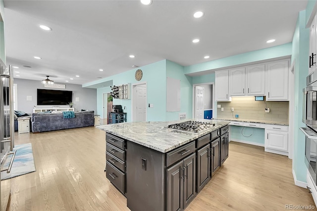 kitchen featuring white cabinetry, decorative backsplash, stainless steel gas stovetop, and dark brown cabinets