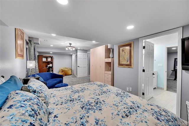 bedroom featuring ensuite bath and light colored carpet