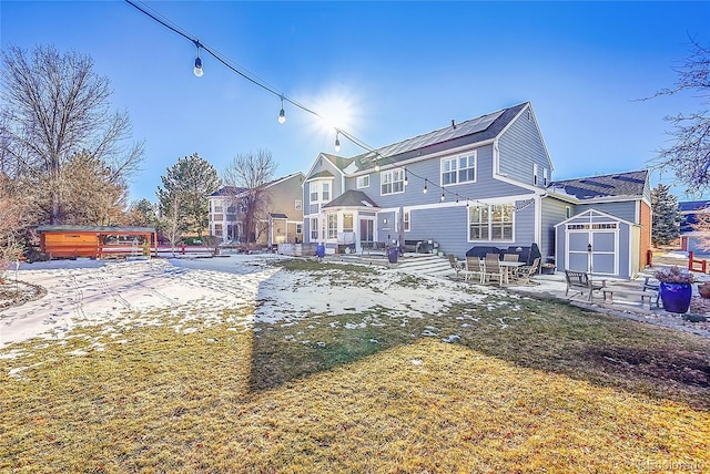 rear view of property featuring a storage shed, a hot tub, and a patio