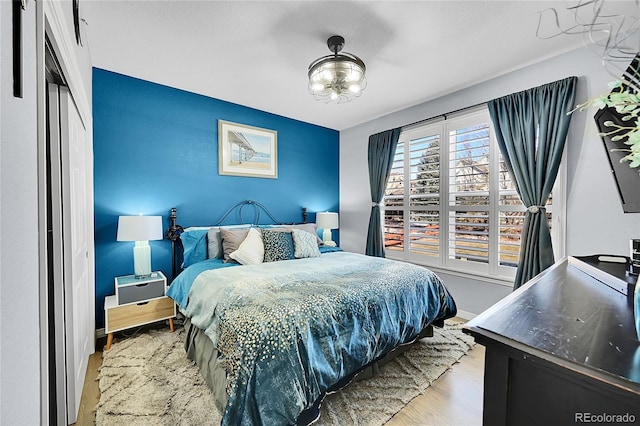 bedroom with light hardwood / wood-style floors and a closet