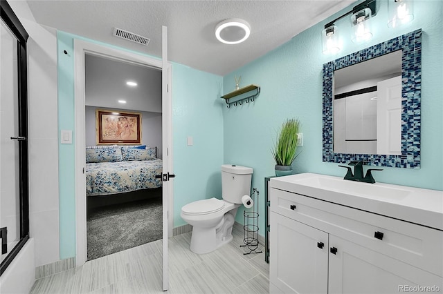 full bathroom with vanity, combined bath / shower with glass door, a textured ceiling, and toilet