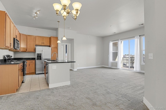 kitchen with dark countertops, stainless steel appliances, and light carpet