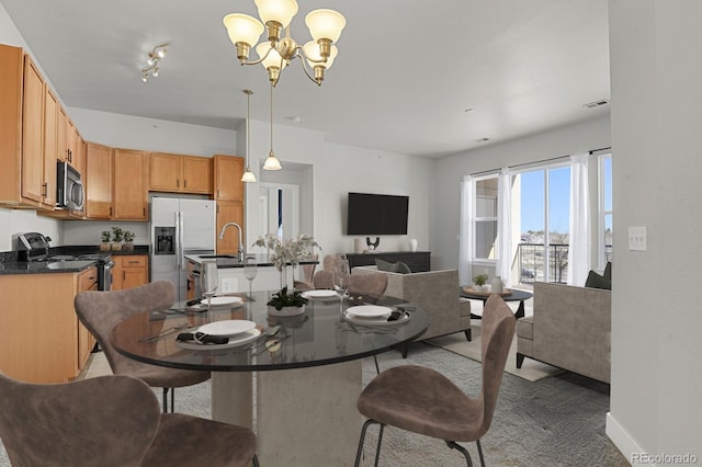14321 E Tennessee Ave Unit 1-301, Aurora, CO 80012 - dining area with a chandelier, carpet floors, baseboards, and visible vents