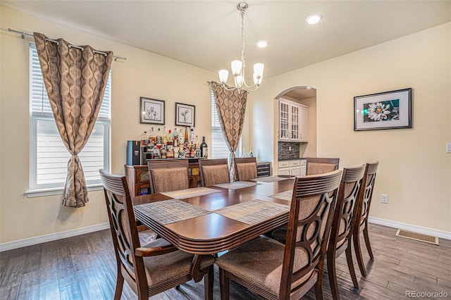 dining space featuring an inviting chandelier, baseboards, and wood finished floors