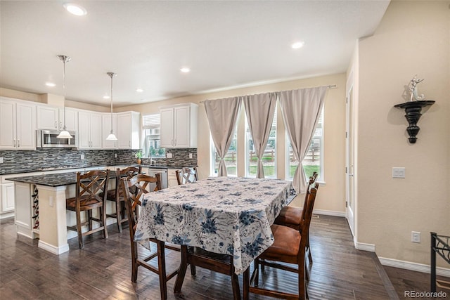 dining space featuring baseboards, dark wood finished floors, and recessed lighting