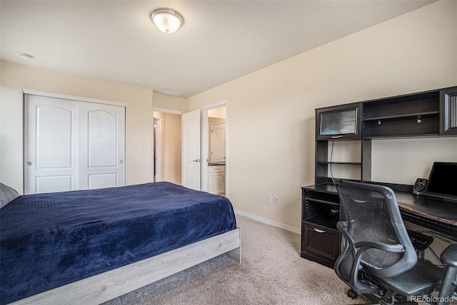 bedroom with carpet, baseboards, a closet, and ensuite bathroom