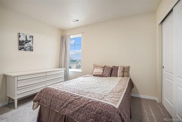 bedroom featuring a closet, carpet flooring, visible vents, and baseboards