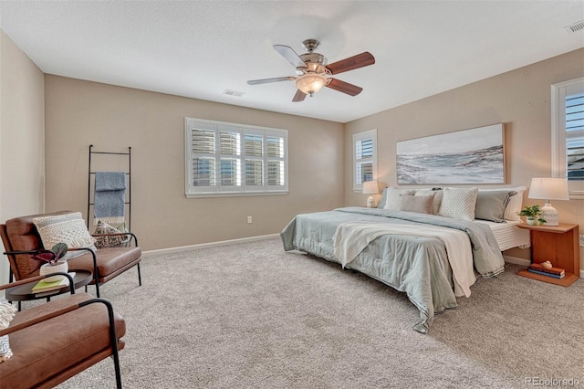 carpeted bedroom featuring ceiling fan, visible vents, and baseboards