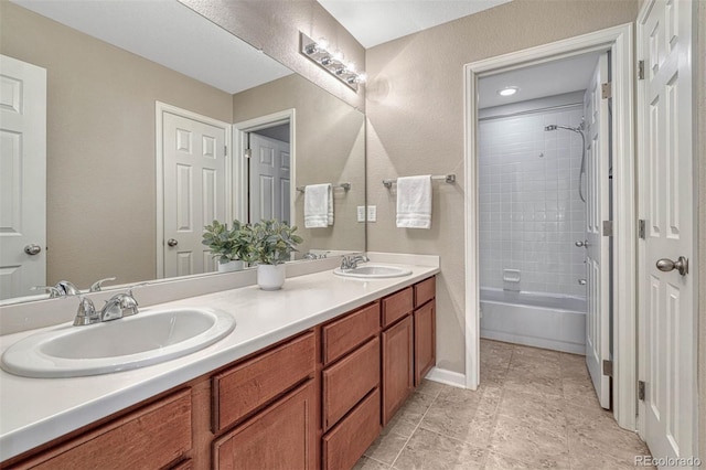 full bathroom with double vanity, baseboards,  shower combination, and a sink