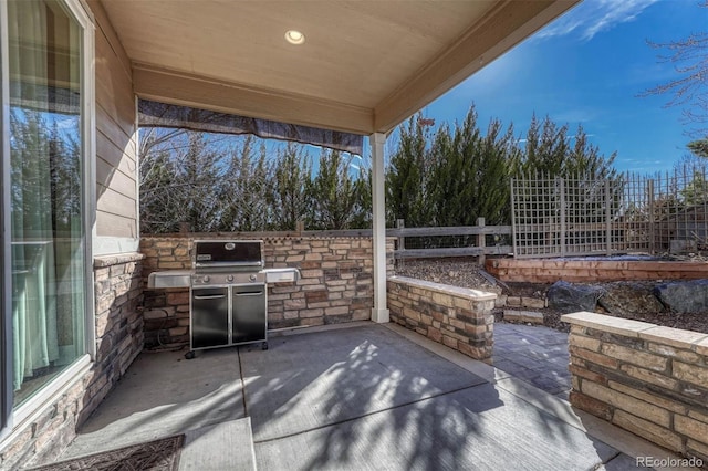 view of patio with a fenced backyard, grilling area, and an outdoor kitchen