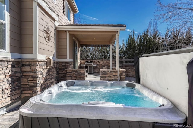 exterior space with a hot tub and grilling area