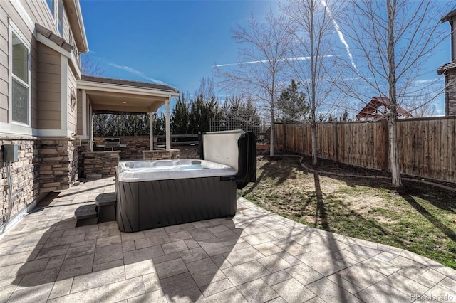 view of patio with a fenced backyard and a hot tub