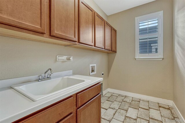 laundry area with cabinet space, baseboards, electric dryer hookup, washer hookup, and a sink