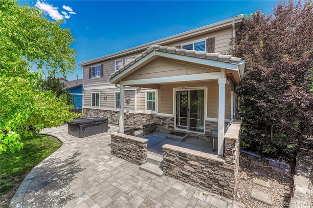 10761 Hillsboro Cir, Parker, CO 80134 - back of house featuring a hot tub, a patio area, and stone siding