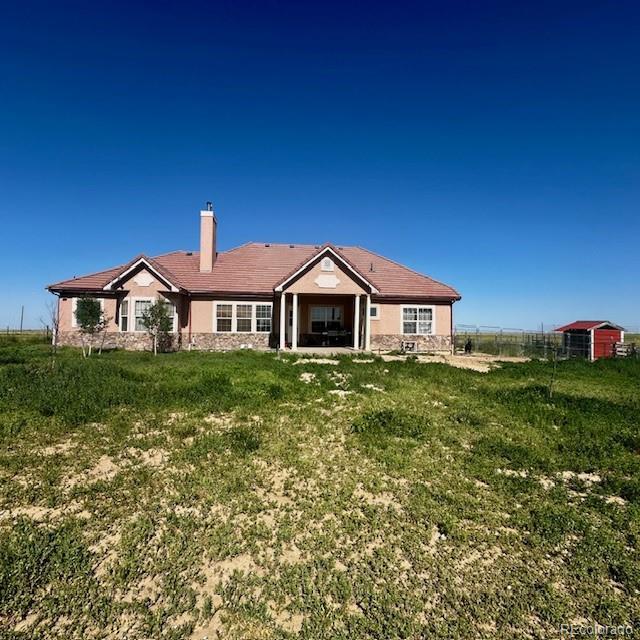 13291 N Harback Rd, Bennett, CO 80102 - rear view of property featuring a chimney and stucco siding