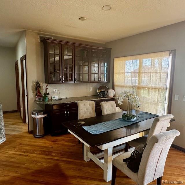 13291 N Harback Rd, Bennett, CO 80102 - dining area with wood finished floors and a textured ceiling