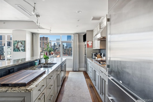 kitchen featuring gray cabinets, appliances with stainless steel finishes, ventilation hood, sink, and a spacious island