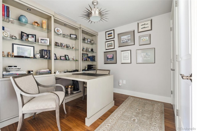 office area with built in shelves and dark hardwood / wood-style floors