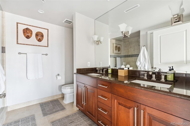 bathroom featuring tiled shower, vanity, toilet, and tile patterned flooring