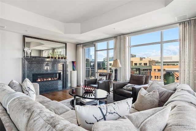 living room featuring a view of city, visible vents, wood finished floors, and a high end fireplace