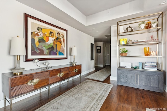 hallway with baseboards and dark wood-type flooring