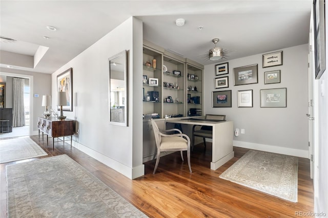 office featuring visible vents, wood finished floors, a ceiling fan, and baseboards