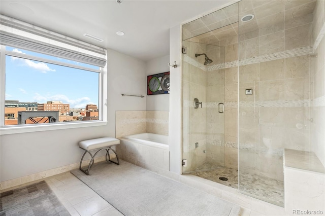 bathroom featuring a view of city, a shower stall, a bath, baseboards, and tile patterned floors